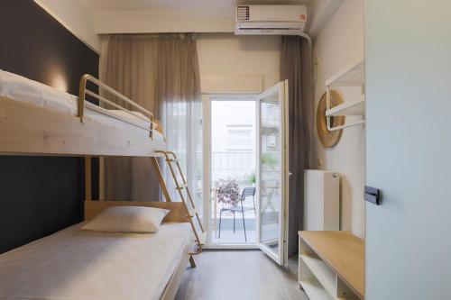een slaapkamer met 2 stapelbedden en een balkon bij Ancient Agora Central Living in Thessaloniki