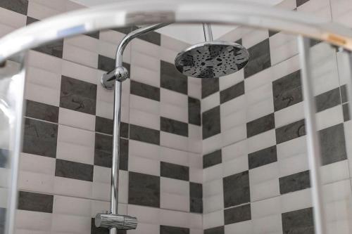 een douchekop in een badkamer met een geblokte muur bij Ancient Agora Central Living in Thessaloniki