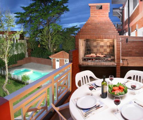 una mesa con un plato de comida en un balcón con una parrilla en el Apart Paradisso de Villa Gesell