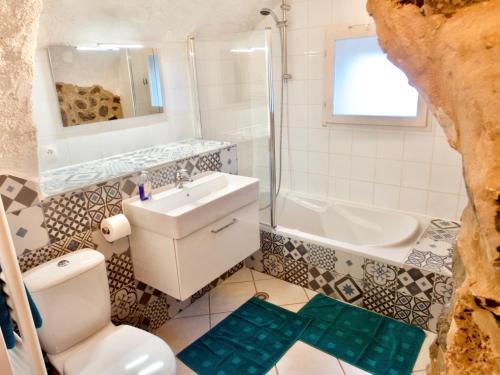a bathroom with a sink and a toilet and a tub at Chalet d'hôtes Auris in Auris
