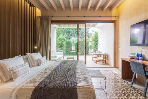 een slaapkamer met een groot bed en een glazen schuifdeur bij Hotel Rural Xereca in Puig D’en Valls