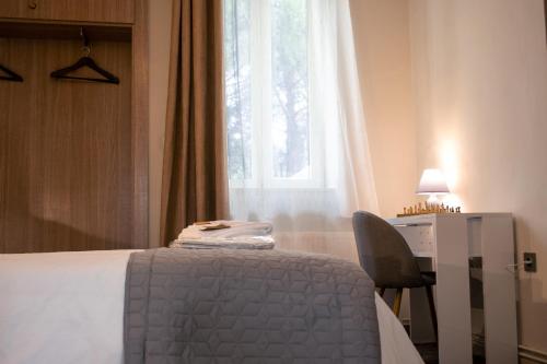 a bedroom with a bed and a desk and a window at Rodon Premium in Kalavrita