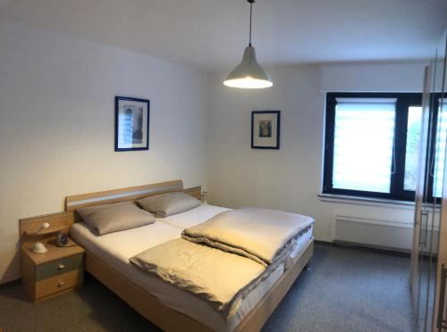 een slaapkamer met een bed en een raam bij Haus Nacke in Möhnesee