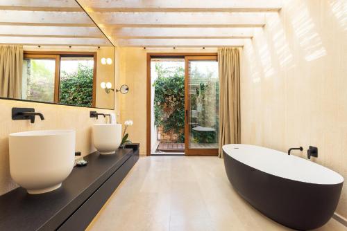 a bathroom with a large tub and two sinks at Hotel Rural Xereca in Puig D’en Valls