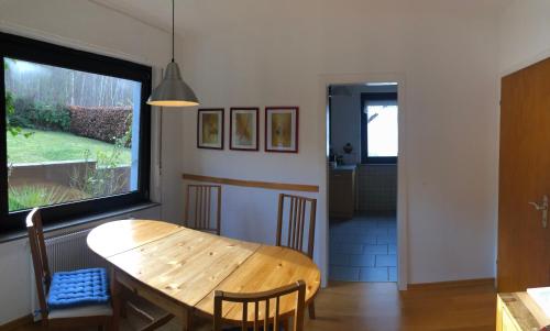 een eetkamer met een houten tafel en een raam bij Haus Nacke in Möhnesee