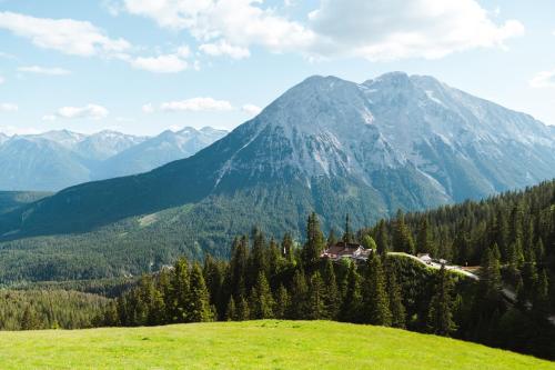 a house on a hill with mountains in the background at Haus Sabine in Leutasch