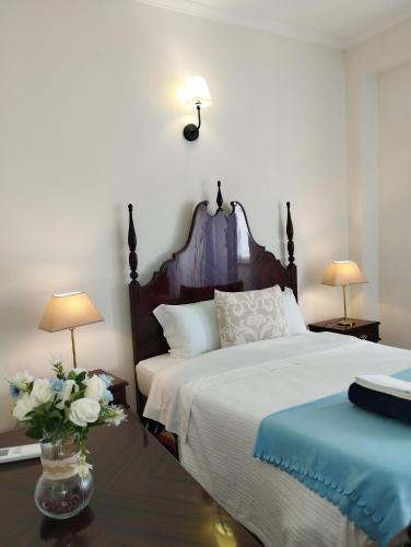 a bedroom with a bed and a vase of flowers on a table at Casa azul in Gouveia