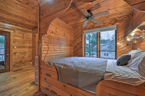 a bedroom of a log cabin with a bed and a window at Waterfront Arkdale Retreat 2 Acres with Deck and View in Arkdale