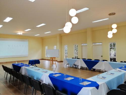 a conference room with tables and chairs and a whiteboard at Hotel Xue Sabana in Cajicá