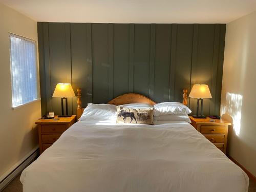 a bedroom with a large white bed with two lamps at Valhalla Vacations at Whistler in Whistler