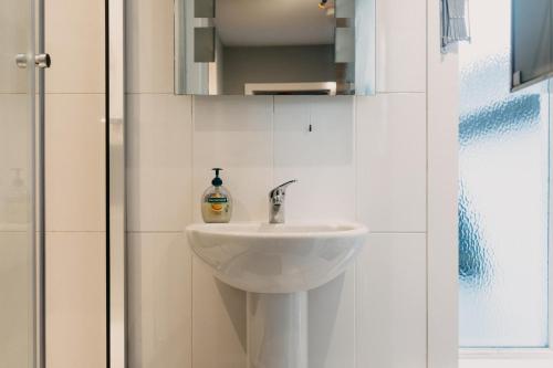 a bathroom with a sink and a shower at Belfast City self catering 3 bedroom town house in Belfast