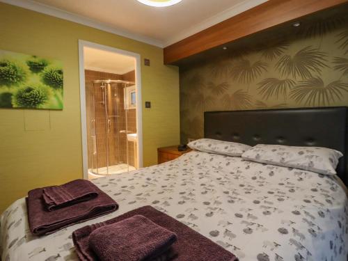 a bedroom with a bed with two towels on it at Swinsty Lodge in Harrogate
