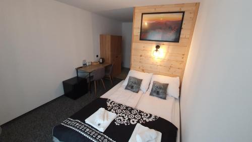 a bedroom with a bed and a wooden wall at Willa Widokowa in Wisła
