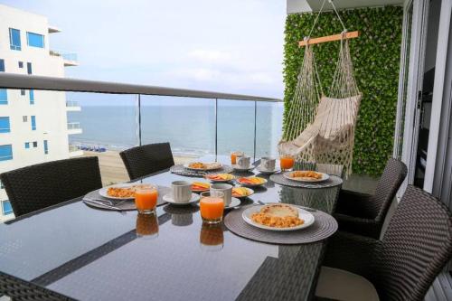una mesa con platos de comida en el balcón en Cerca al Hotel Americas Ctgna Spiaggia Morros Piscina playa, en Cartagena de Indias