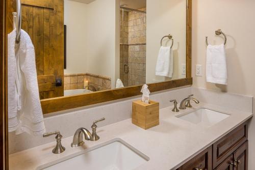 a bathroom with two sinks and a large mirror at Western Tanager Cabin in Big Sky