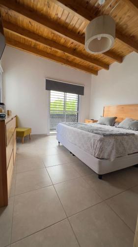 sypialnia z dużym łóżkiem i dużym oknem w obiekcie Casa Yaqui w mieście Guaymallén
