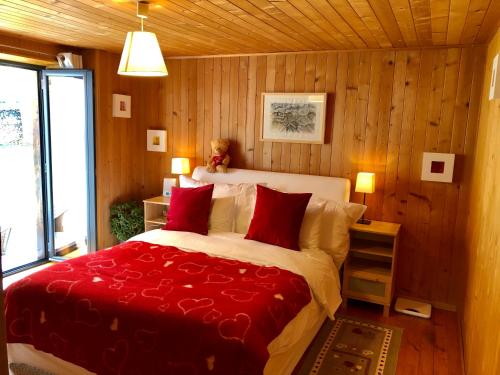 ein Schlafzimmer mit einem großen Bett mit roten Kissen in der Unterkunft Magnifique Maison près du centre in Nendaz