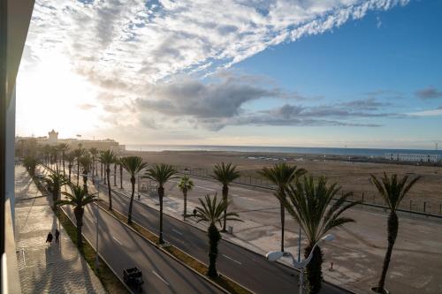 a view of a street with palm trees and the beach at PUERTO MARINA ASILAH in Asilah