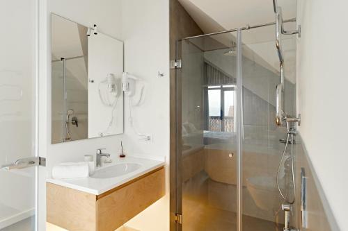 a bathroom with a sink and a glass shower at Dilijani Tun Hotel & Restaurant in Dilijan