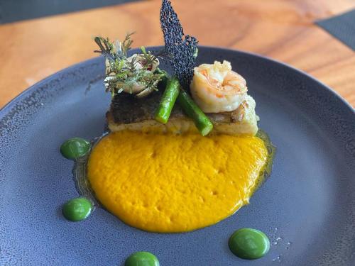 a plate of food with shrimp on top of an orange peel at Café de Playa Beach Front Hotel in Coco
