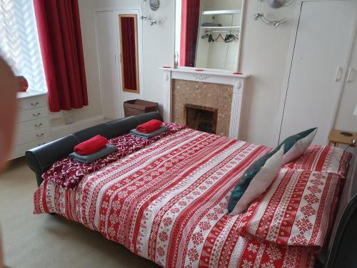 a bedroom with a bed with a red blanket and a fireplace at Alastrean Flat in Aberdeen