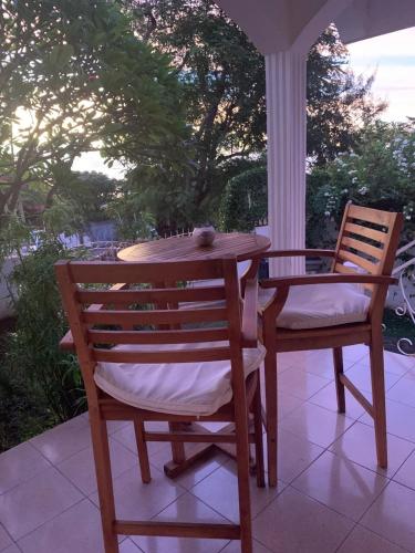 a wooden table and two chairs on a porch at Le Caillou Blanc in Saint-Paul