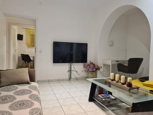 a living room with a couch and a tv at Renovierte Ferienwohnung im Zentrum von Locarno in Locarno