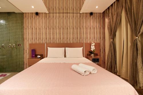 a bedroom with a large bed with towels on it at Intense Motel in São Paulo