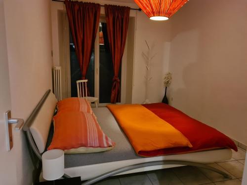 uma cama com almofadas coloridas num quarto em Renovierte Ferienwohnung im Zentrum von Locarno em Locarno