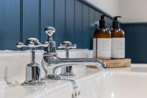 a bathroom sink with a faucet and two bottles of soap at Stags Mount in Pickering