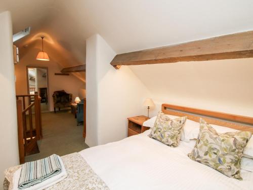 a bedroom with a bed with white sheets and pillows at Walkmill Barn in Bishops Castle