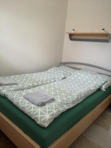 a bed in a room with a green mattress at Dorka apartman in Vonyarcvashegy