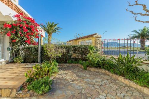 una casa con una pasarela de piedra con flores rojas en V020 - PUERTO PRIMERO en Ampuriabrava