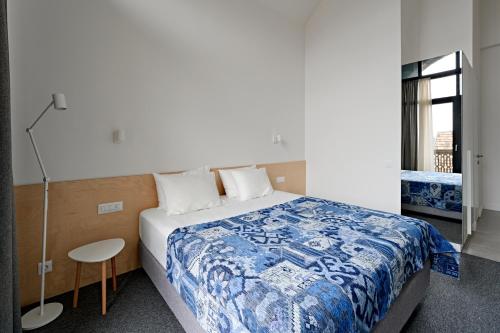 a bedroom with a large bed with a blue and white blanket at Dilijani Tun Hotel & Restaurant in Dilijan