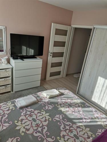 sypialnia z łóżkiem z komodą i telewizorem w obiekcie Markoni w mieście Sliwen