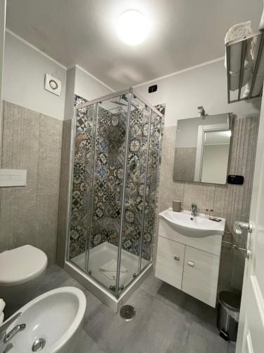 y baño con ducha, aseo y lavamanos. en ALDIVA ROOMS, en Torvaianica