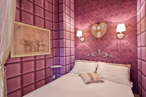 - une chambre avec des murs violets et un lit dans l'établissement Studio Alberti, à Nice