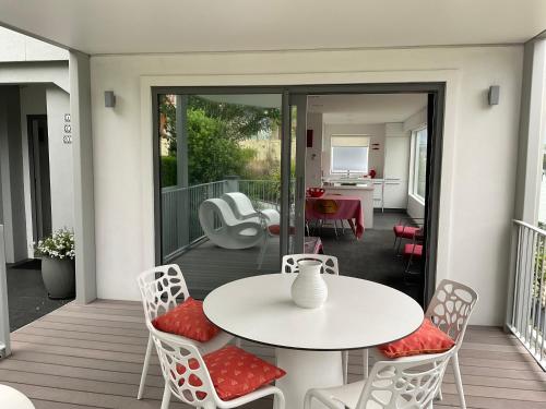 un patio con mesa y sillas en una terraza en Casa Vista Apartment by Amazing Accom, en Queenstown