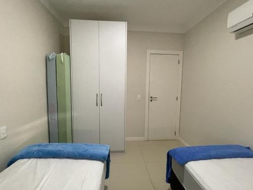 Habitación hospitalaria con 2 camas y armario en 1053 - Praia de Bombinhas locação de temporada - Residencial Egídio Pinheiro Apto 302 B, en Bombinhas