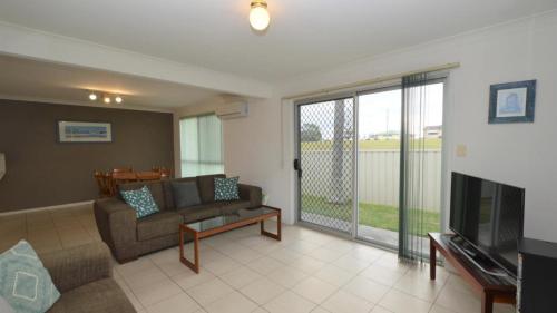 a living room with a couch and a television at Sunnyvale unit 1 in Yamba