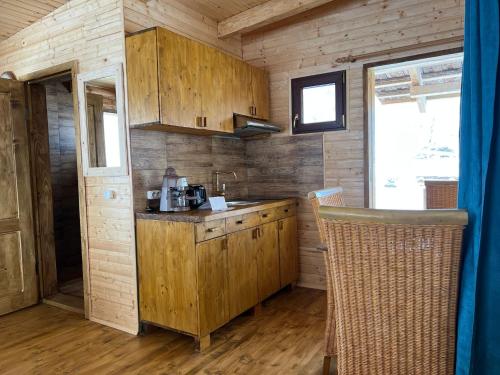 a kitchen with wooden cabinets and a counter top at Cabana Himalaya Lodge cu ciubăr din inima munților Apuseni- masivul Buces -Vulcan 