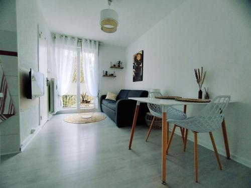 uma sala de estar com um sofá e uma mesa em Studio avec balcon à 5 min de la gare em Chalon-sur-Saône