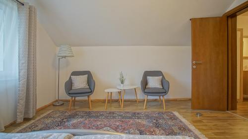 a room with two chairs and a table and a table at Vilux with indoor private parking in Braşov