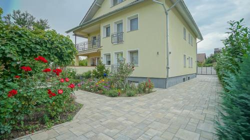 a large yellow house with a brick driveway at Vilux with indoor private parking in Braşov