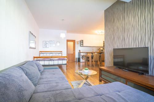 ein Wohnzimmer mit einem Sofa und einem Flachbild-TV in der Unterkunft TATRYSTAY Great Apartment - 2 King size beds in Veľká Lomnica