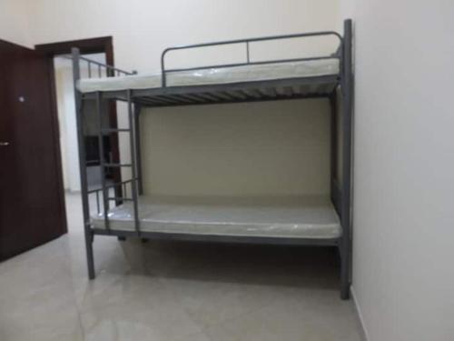 een stapelbed in een kleine kamer met bij Stay at gomeetingwith in Sharjah