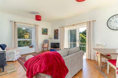 a living room with a couch and a clock on the wall at Folly View - Private, peaceful apartment with stunning views. in Pateley Bridge