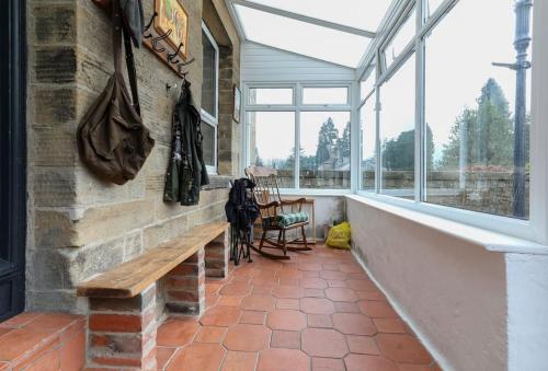 a brick wall with a bench in a room with windows at Folly View - Private, peaceful apartment with stunning views. in Pateley Bridge