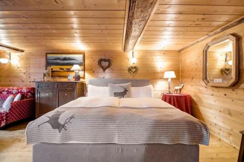 ein Schlafzimmer mit einem großen Bett in einem Holzzimmer in der Unterkunft "CHALET dei FIORI" room & apartment in Bedretto