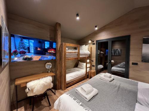 a bedroom with two bunk beds and a bathroom at Luxury Summit Penthouse - Soldeu - By Ski Chalet Andorra in Soldeu